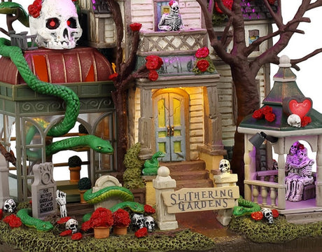 Resin lighted building for a Lemax display. Designed to look like a semi-rundown mansion. There are snakes everywhere and a large sugar skull statue on the roof. There's a gazebo with a skeleton couple hugging inside. There are flowers and skulls and tombstones and a skeleton standing on the balcony.