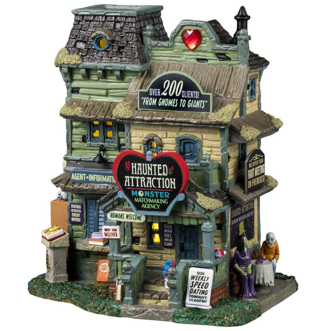 Porcelain lighted building for a Lemax display. Designed to look like light green three story building with moss growing on the roof. The top sign reads "OVER 200 CLIENTS! FROM GNOMES TO GIANTS!" The sign above the front door is shaped like a heart and reads "HAUNTED ATTRACTION. MONSTER MATCHMAKING AGENCY." There are two monsters on a date on the side of the building.
