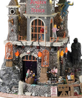 Resin lighted building for a Spooky Town display. Designed to look like a tall dungeon built into a stone mountain. There are dragons flying around the roof, a Grim Reaper off to the site and skeletons in cages. There's a ride that goes through the dungeon and there are kids in the carts.