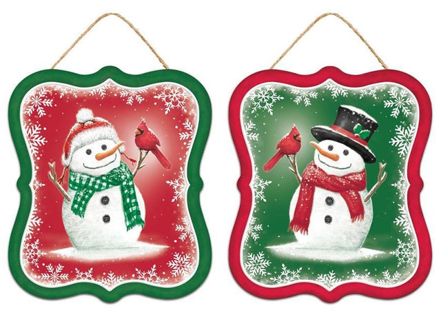Winter ornament featuring a snowman smiling at a cardinal. One ornament has a green border and a red background. That snowman is wearing a red Santa hat and a green scarf. One ornament has a red border and a green background. That snowman is wearing a black top hat and a red scarf.
