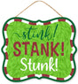 Hanging holiday sign that reads "stink! STANK! Stunk!" in a green, red glitter and white font. The background is designed to look like green fur. There's a red and white border up against a solid green border. Hangs from a jute rope.