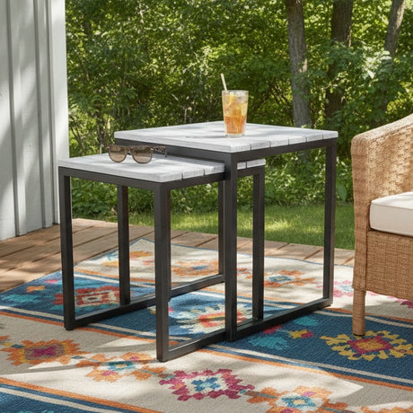 This is a lifestyle image showing the end tables on a colorful outdoor rug on the side of a house.