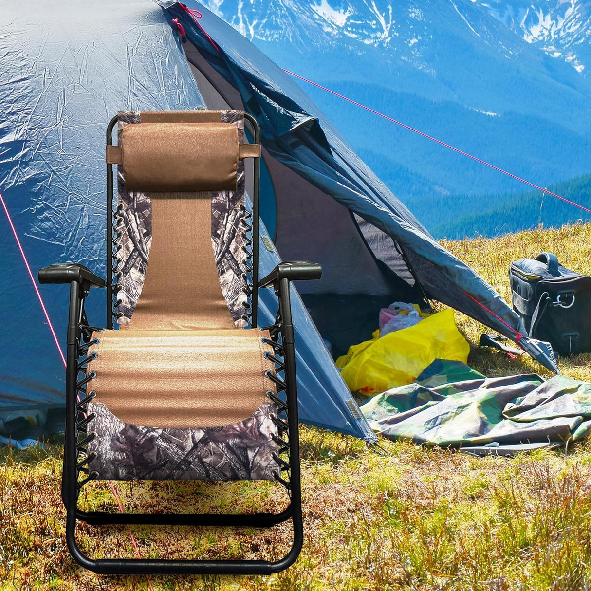 Folding recliner chair with a headrest. There are different color options. This image shows a black frame chair with camouflage sling fabric. It's sitting in a campsite near a mountain.