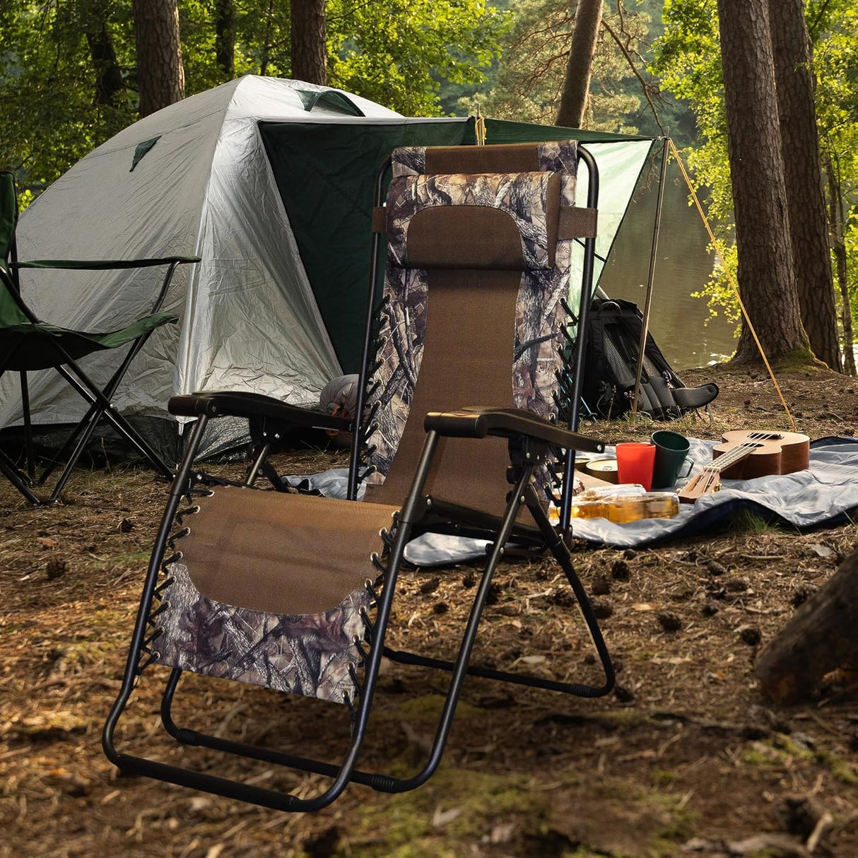 Folding recliner chair with a headrest. There are different color options. This image shows a black frame chair with camouflage sling fabric. It's sitting in a campsite in the middle of the woods.