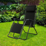Folding recliner chair with a headrest. There are different color options. This image shows a black frame chair with black sling fabric. It's sitting on grass in a sunny backyard.