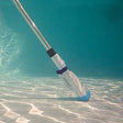 This is a lifestyle image showing the pool vacuum in use at the bottom of a pool.