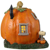 Resin village accent for a Lemax display. Designed to look like a cabin made out of a pumpkin. There are black cats and pumpkin accents. There's also a gray chair outside near the front door.