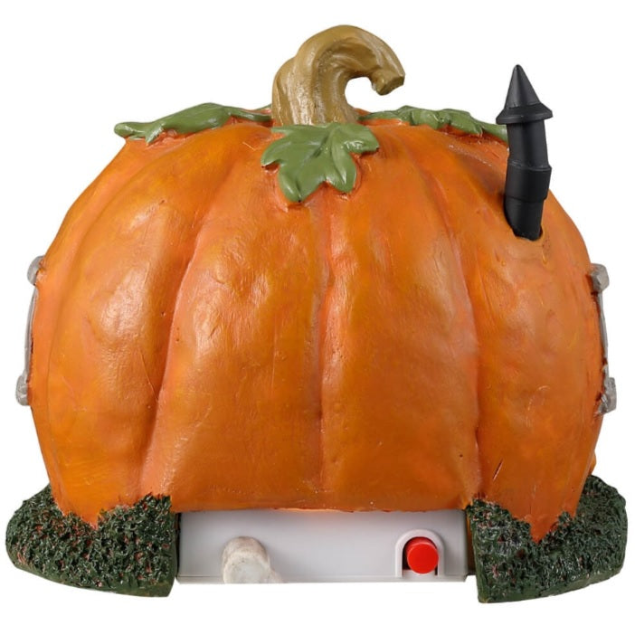 Resin village accent for a Lemax display. Designed to look like a cabin made out of a pumpkin. There are black cats and pumpkin accents. There's also a gray chair outside near the front door.
