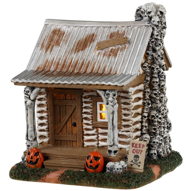 Resin village accent for a Lemax display. Designed to look like an old cabin made out of bones and skulls and wood. There are carved pumpkins on either side of the front door along with a sign that reads "KEEP OUT!"
