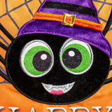 Outdoor Halloween flag. The background is orange and has a gray spiderweb. There are three large, smiling spiders and a message that reads "HAPPY HALLOWEEN." The spiders are all wearing colorful hats. One is pink, one is lime green and one is purple.