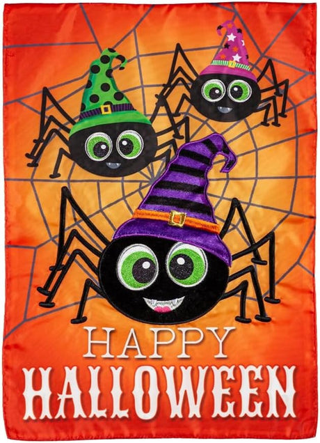 Outdoor Halloween flag. The background is orange and has a gray spiderweb. There are three large, smiling spiders and a message that reads "HAPPY HALLOWEEN." The spiders are all wearing colorful hats. One is pink, one is lime green and one is purple.