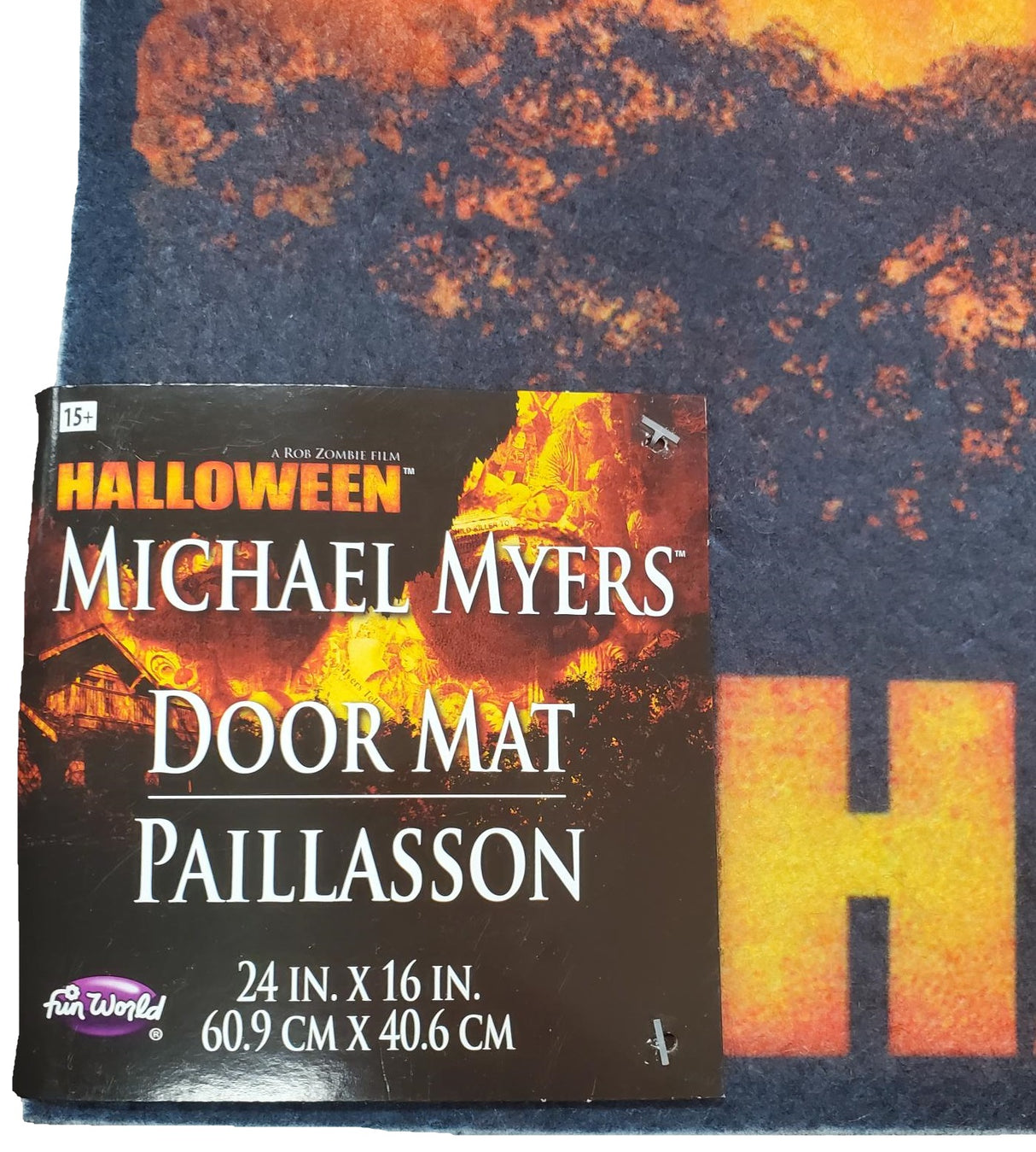 Rug for Halloween. There are two options. One is black with Ghost Face holding a knife. The other option is red and orange and reads "Halloween: A Rob Zombie Film." It has Michael Myers holding a knife in front of a home.