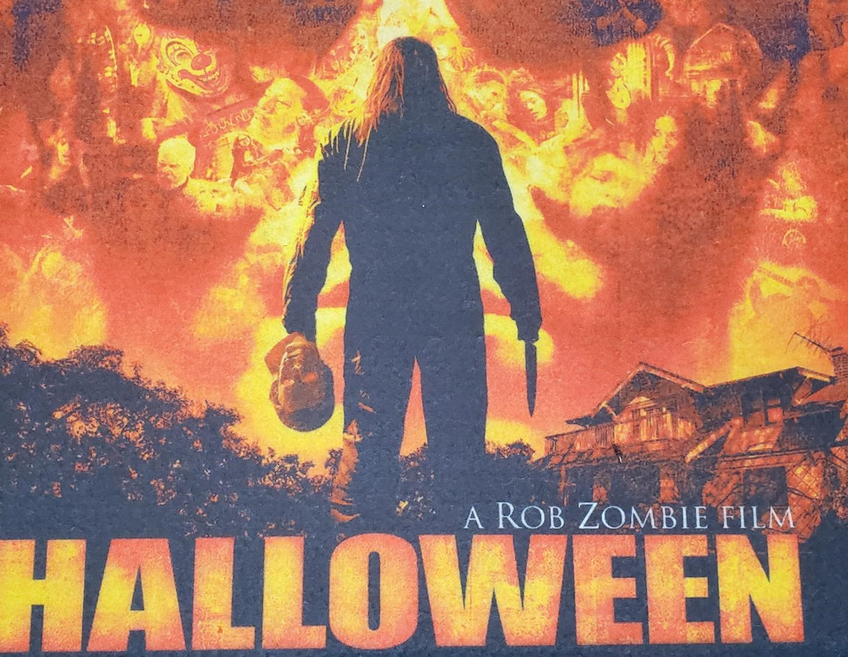 Rug for Halloween. There are two options. One is black with Ghost Face holding a knife. The other option is red and orange and reads "Halloween: A Rob Zombie Film." It has Michael Myers holding a knife in front of a home.