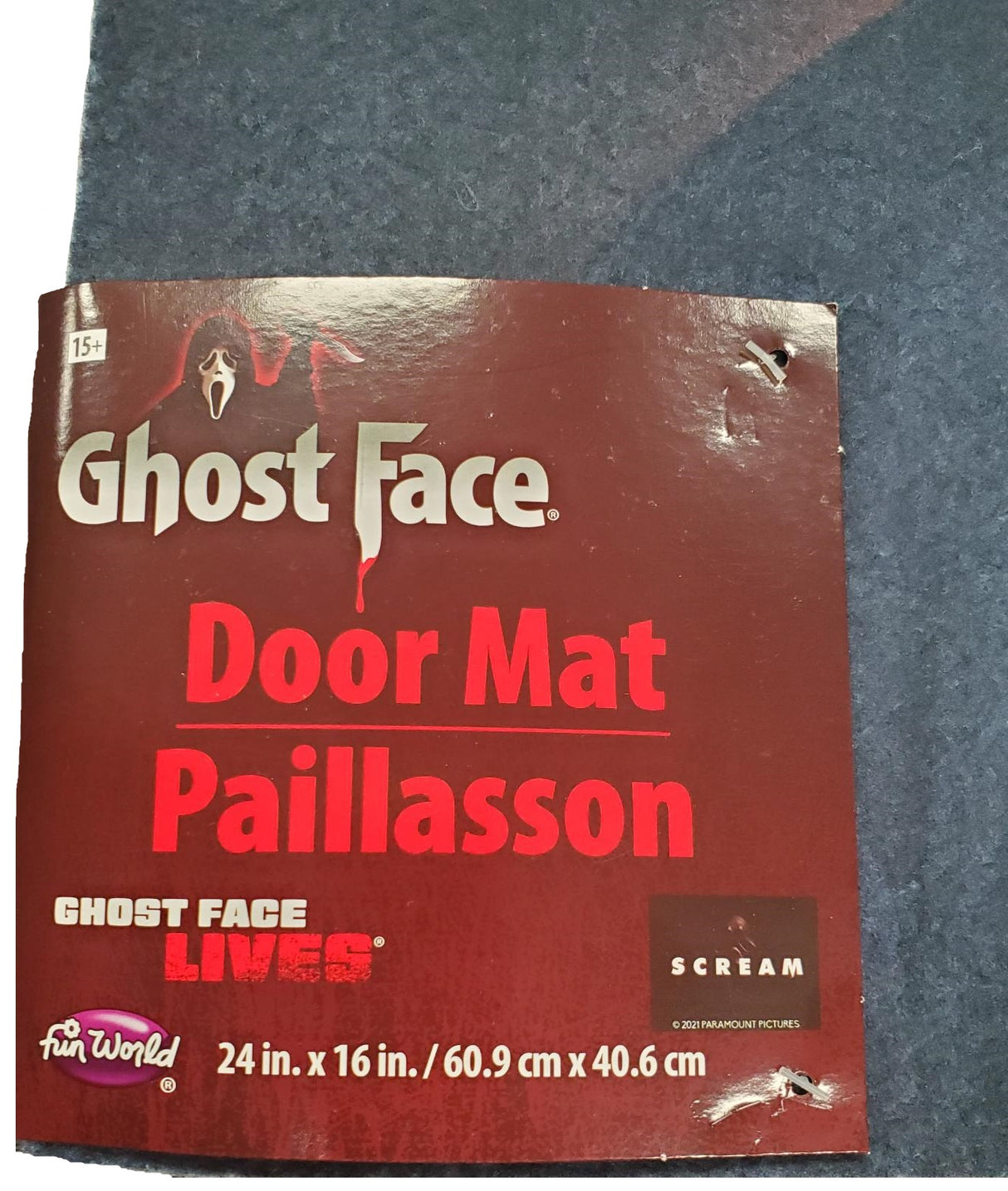 Rug for Halloween. There are two options. One is black with Ghost Face holding a knife. The other option is red and orange and reads "Halloween: A Rob Zombie Film." It has Michael Myers holding a knife in front of a home.