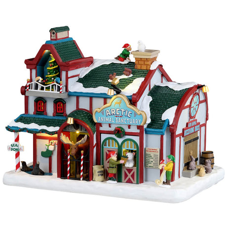 Resin lighted building for a Lemax display. Designed to look like a snow covered animal sanctuary. There are elves everywhere helping with the animals and helping to decorate a Christmas tree on the balcony.
