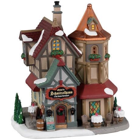 Porcelain lighted building for a Lemax display. Designed to look like a German restaurant. There's snow on the roof and the sidewalk. There are tables available outside.