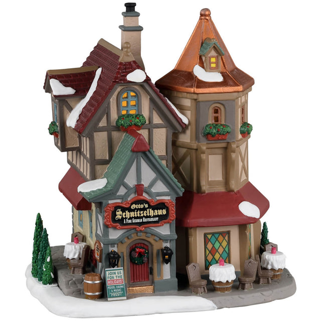 Porcelain lighted building for a Lemax display. Designed to look like a German restaurant. There's snow on the roof and the sidewalk. There are tables available outside.