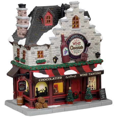 Porcelain lighted building for a Lemax display. Designed to look like a wine and chocolate tasting restaurant. There's a statue of a wine bottle, a wine glass and a piece of chocolate on the front. There are two decorated trees near the front door and a bunch of barrels on the sidewalk.