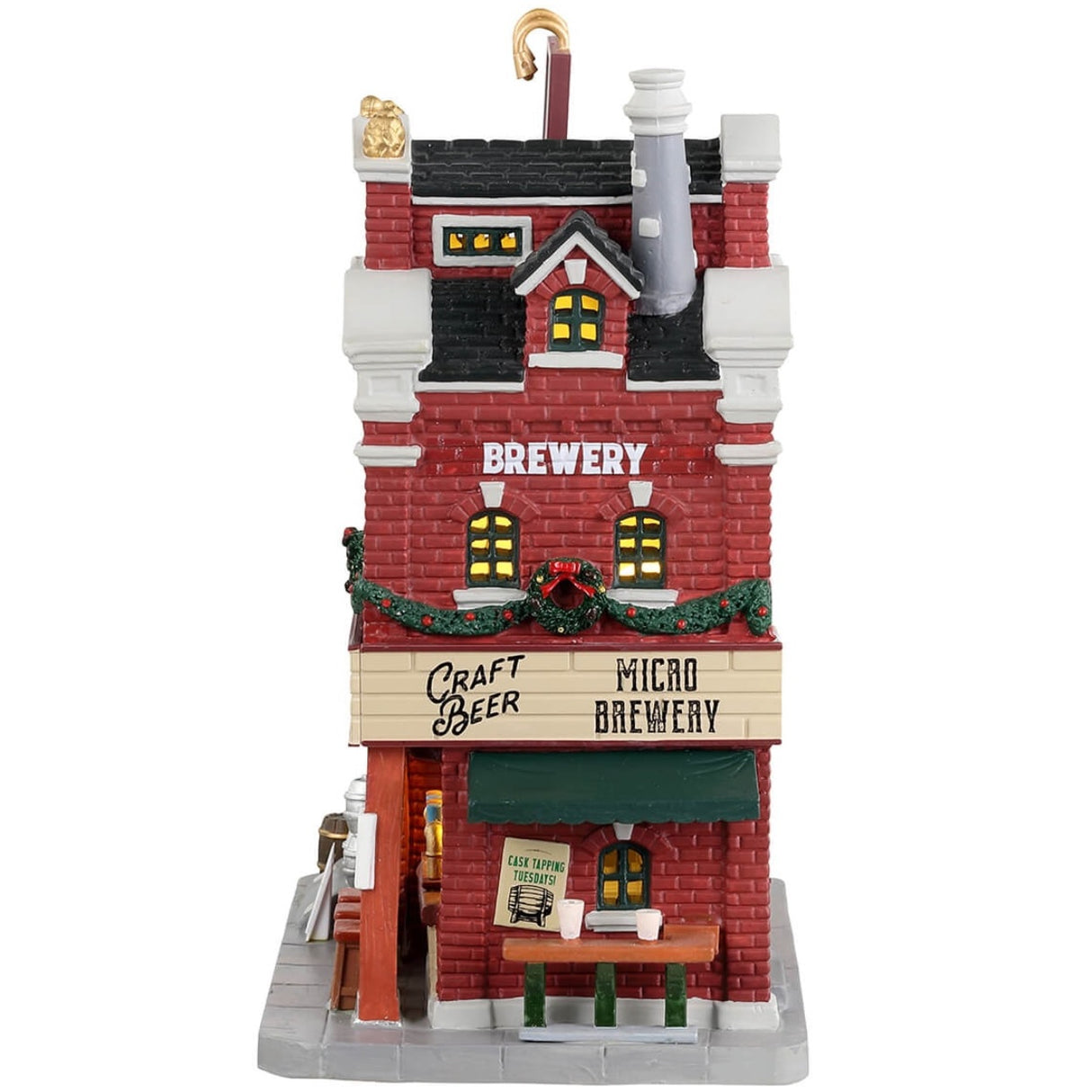Porcelain lighted building for a Lemax display. Designed to look like a large, brick brewery. There are silver barrels of beer on the roof, decorated wreaths and garland and stools outside for patrons to enjoy drinking on the sidewalk by the bar.