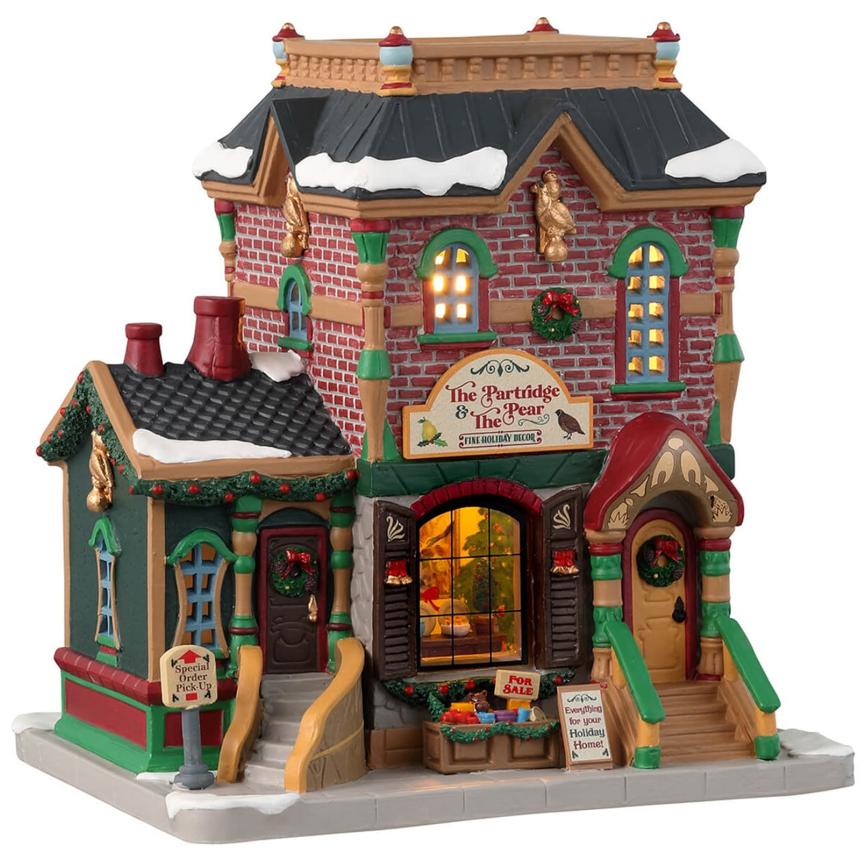 Porcelain lighted building for a Lemax display. Designed to look like a brick building decorated for Christmas with wreaths and garlands. There's snow on the roof and on the sidewalk. 