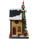 Resin lighted building for a Lemax display. Designed to look like a Christmas store. There are decorative ornaments on the roof, a large decorated Christmas tree over the front door, a nutcracker, presents and a snowman on the sidewalk.