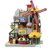 Plastic lighted building for a Lemax display. Designed to look like a large muffin shop. There's a large red windmill with a large muffin statue on the roof. The windmill reads "BANANA, CINNAMON, CHOCOLATE, BLUEBERRY."