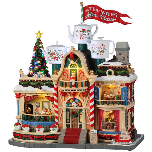 Resin lighted building for a Lemax display. Designed to look like building decorated for Christmas. There are three large mug statues on the roof and a large red flag that reads "TEA WITH MRS. CLAUS."