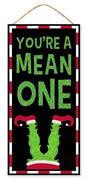 Hanging sign decoration for Christmas. The border is red and white striped. The background is black and reads "YOU'RE A MEAN ONE" and features Grinch legs with red elf shoes. The text is decorated with green glitter.