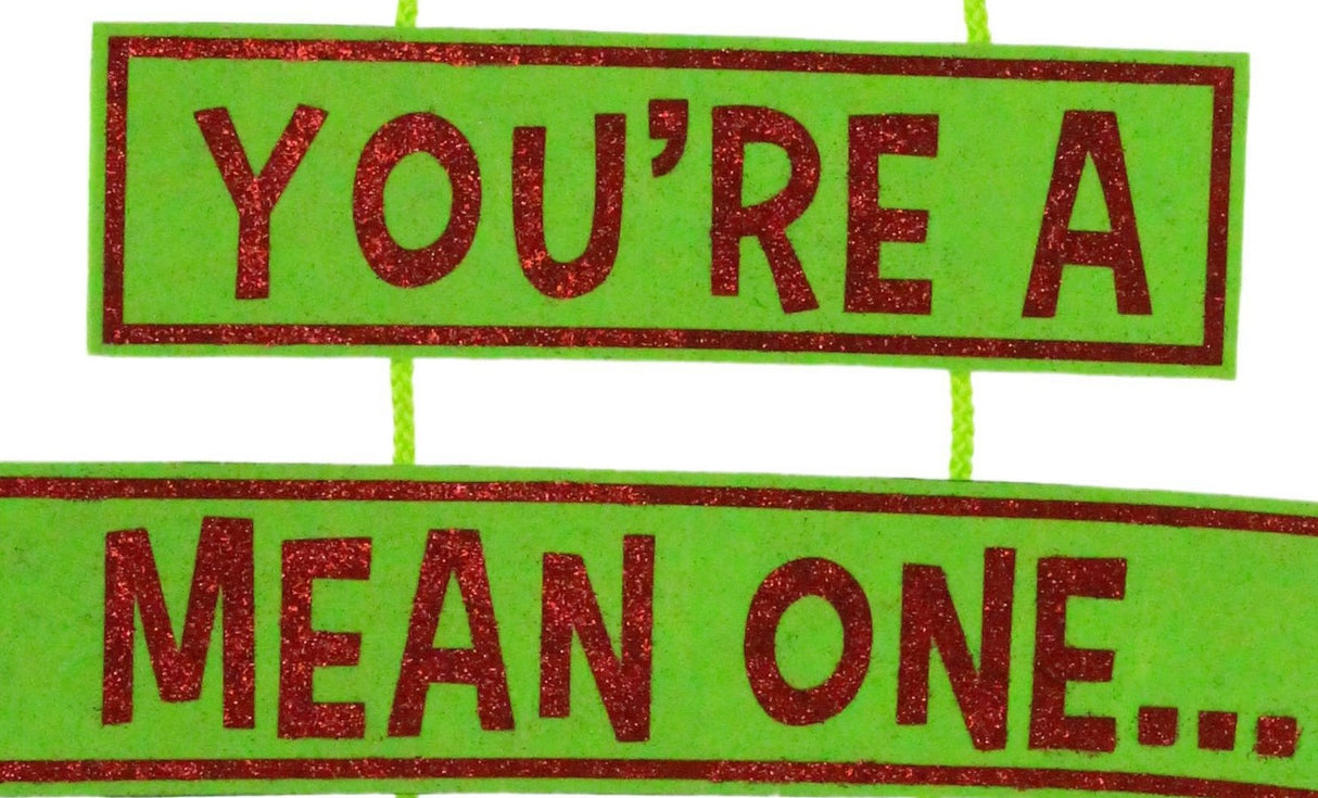 Hanging decoration for Christmas. The top is a red Santa hat with a white cuff and a white ball at the tip of the hat. Underneath that is a sign that reads "YOU'RE A MEAN ONE" and the text is colored with red glitter. Under that are two green furry legs with red elf shoes.