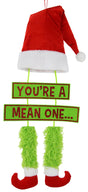 Hanging decoration for Christmas. The top is a red Santa hat with a white cuff and a white ball at the tip of the hat. Underneath that is a sign that reads "YOU'RE A MEAN ONE" and the text is colored with red glitter. Under that are two green furry legs with red elf shoes.