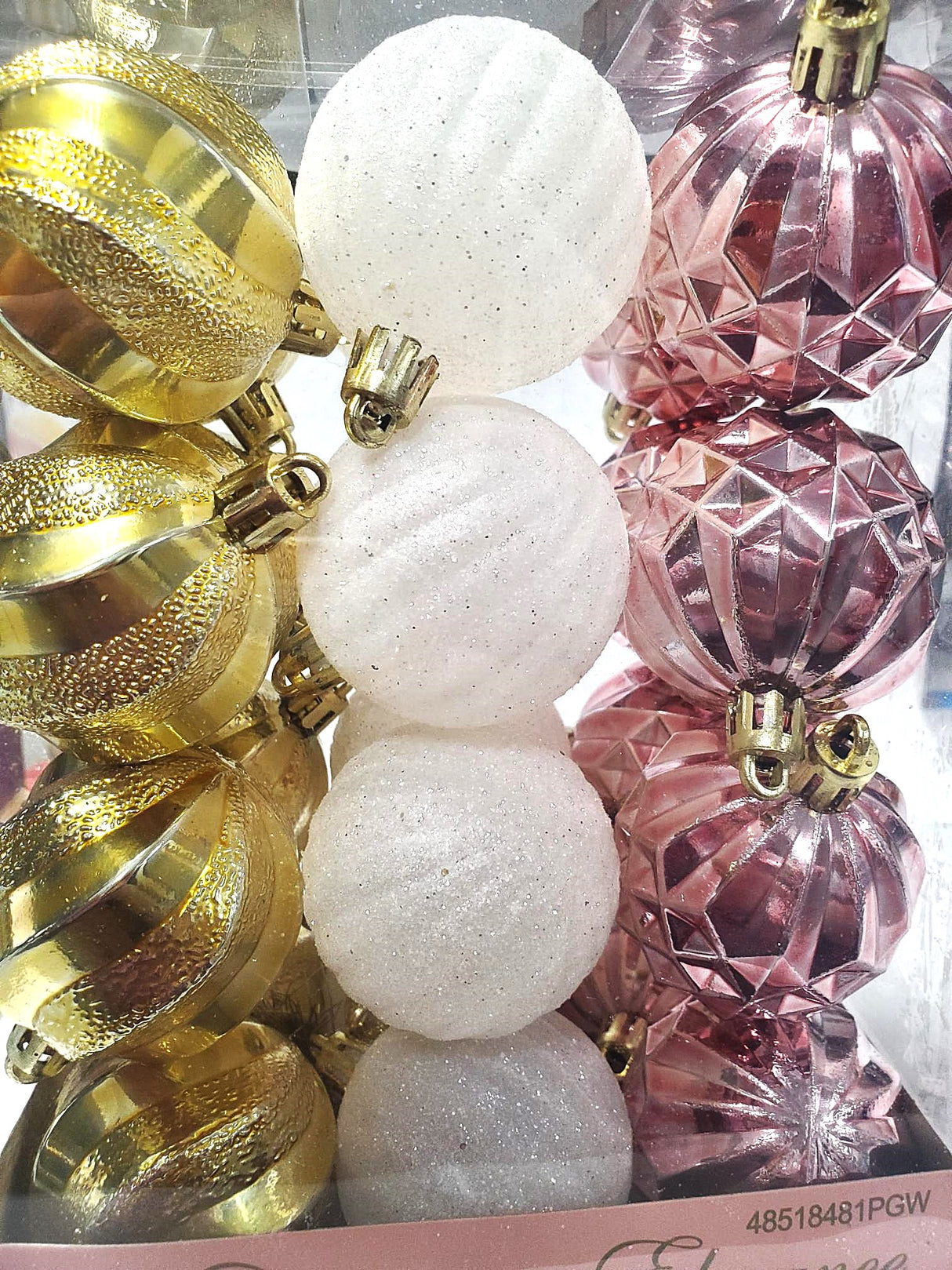 Set of 24 ornaments with different textures. 8 of the ornaments are a shiny gold color. 8 of the ornaments are a glittered white color. 8 of the ornaments are a shiny rose gold color.