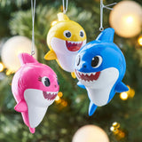 Baby Shark themed ornaments. Baby Shark is yellow. Mommy Shark is pink. Daddy Shark is blue.