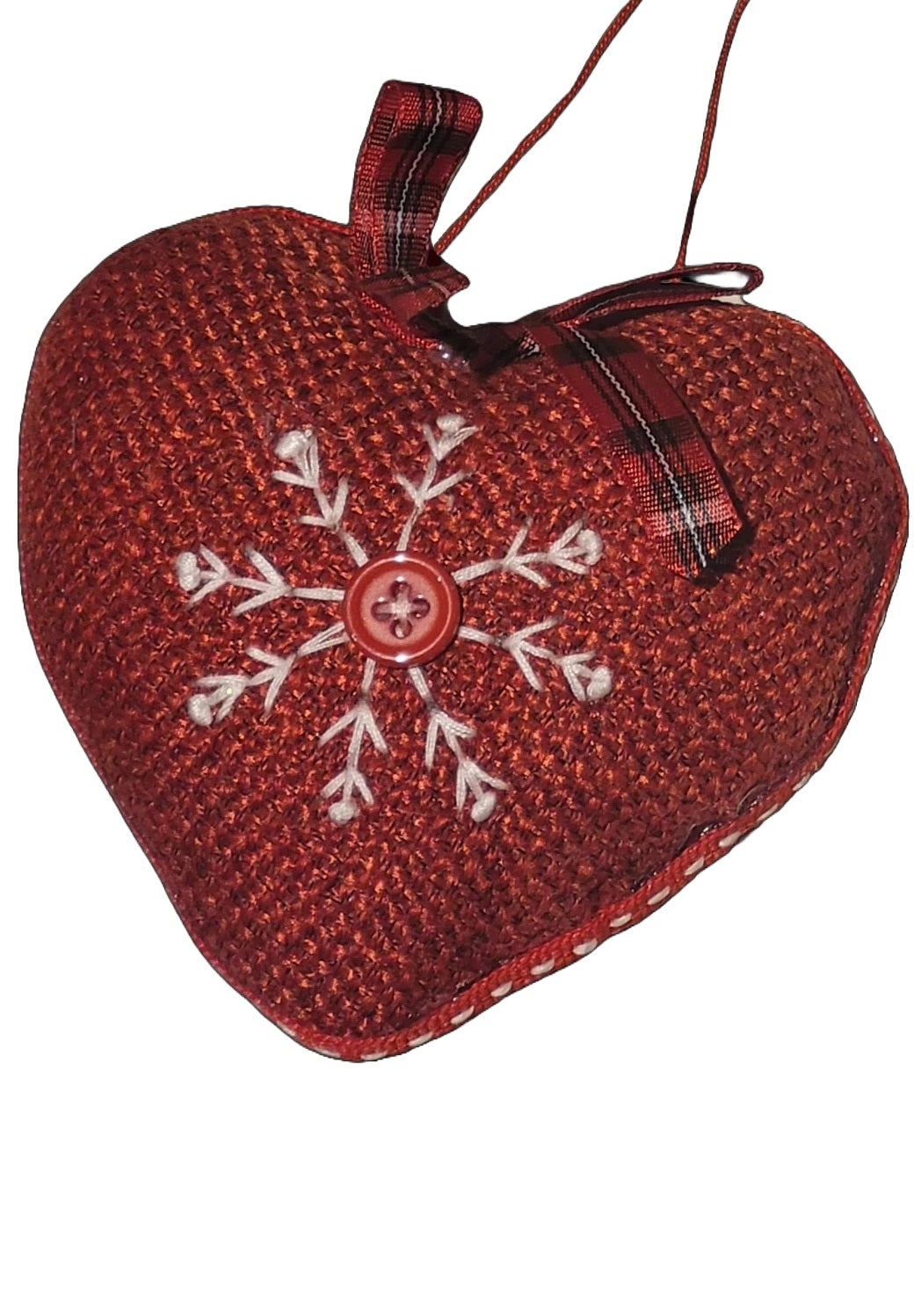 Heart-shaped Christmas ornament. One ornament is red with a white snowflake in the center. One ornament is white with a red snowflake in the center.