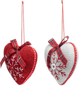 Heart-shaped Christmas ornament. One ornament is red with a white snowflake in the center. One ornament is white with a red snowflake in the center.