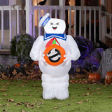 Halloween inflatable shaped like the Stay Puft Marshmallow Man from the movie Ghostbusters. He's holding a pumpkin with the Ghostbusters logo on it.