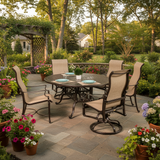 This is a lifestyle image showing this sling patio dining set on a brick patio surrounded by potted plants.