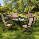 This is a lifestyle image showing this aluminum dining set with sling fabric backs in a grassy backyard on a sunny day.