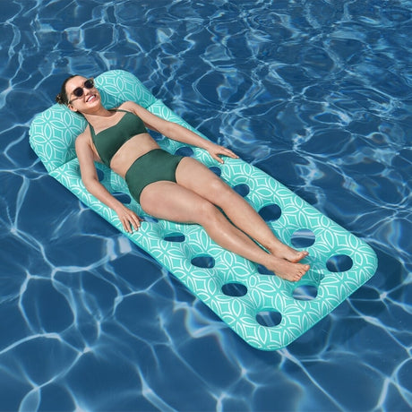 This is a lifestyle image showing a woman laying on the pool float in the pool.