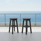 This is a lifestyle image showing two stools on a white balcony overlooking a body of water.