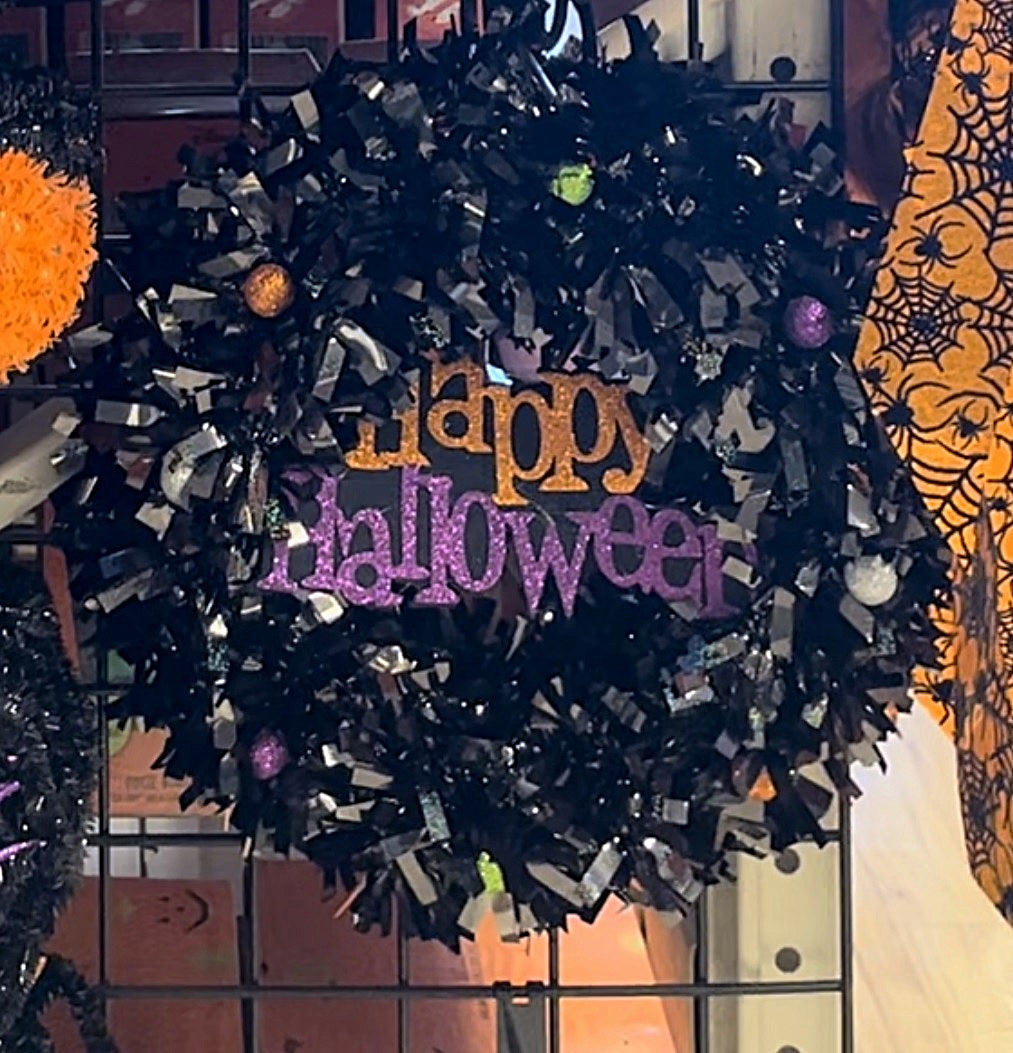 Black tinsel wreath that reads "Happy Halloween."