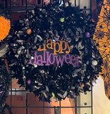 Black tinsel wreath that reads "Happy Halloween."