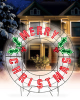Outdoor LED decoration that reads "Merry Christmas." The text is red. There are green holly leaves and red berries.