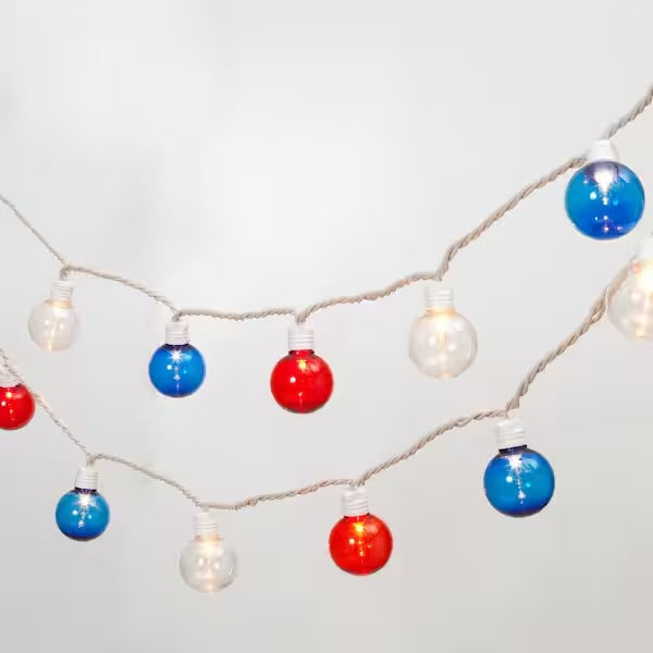 String of red, white and blue globe lights set on a gray background.