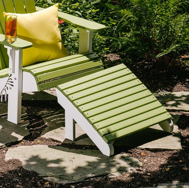 This is a lifestyle image showing the Lime Green and White Adirondack footrest in front of a matching Adirondack chair outside on a patio.