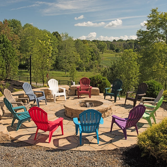 Different colored Adirondack chairs around a fire pit.