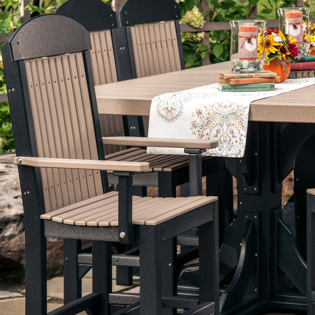 This is a lifestyle image showing Weatherwood and Black colored Classic Arm Chairs around a matching dining table.
