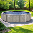 A semi-inground pool on a cement patio in a grassy backyard.