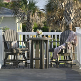 This is a lifestyle image showing a Coastal Gray colored Balcony Table in between two matching chairs on a wooden back patio.