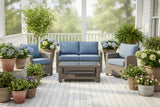 This is a lifestyle image showing this cushioned patio furniture set on a white, wooden porch surrounded by potted plants.