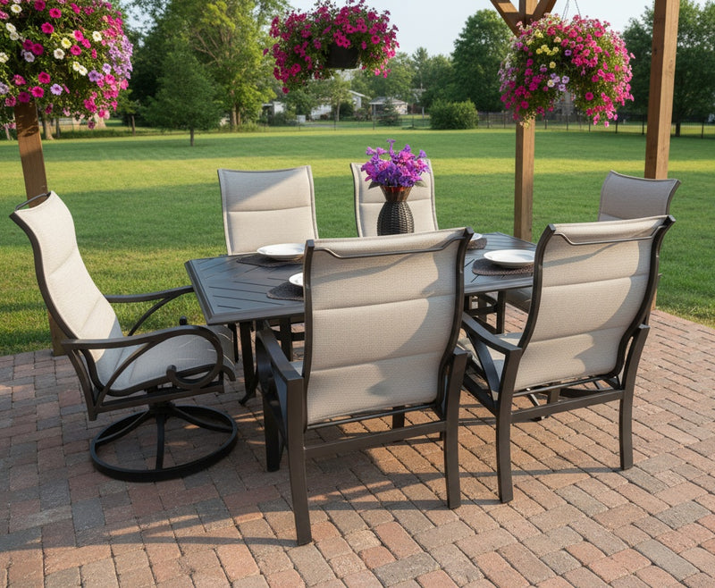 This is a lifestyle image showing the light gray and dark gray colored patio dining set on a brick patio in a grassy, sunny backyard.